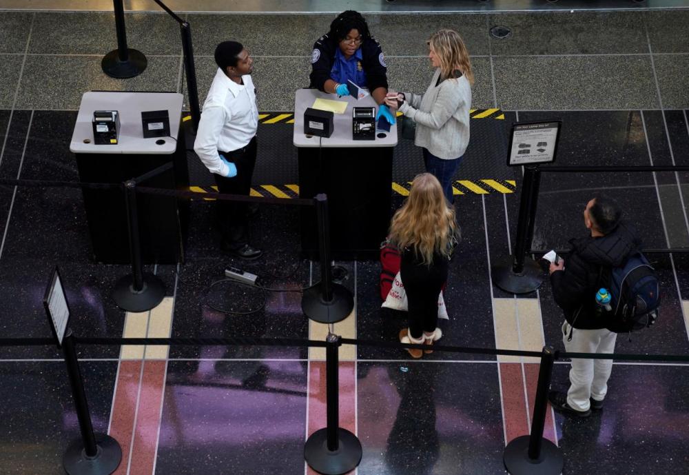 An employee with the Transportation Security Administration (TSA) checks the documents of a traveler at Reagan National Airport in Washington
